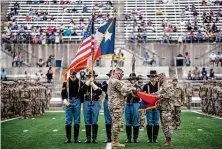  ??  ?? Maj. Gen. Patrick Hamilton, center, takes part in a “casing” ceremony, in which the 36th Infantry Division’s colors are put away, at the stadium. The Guard troops will be deployed for nine months.