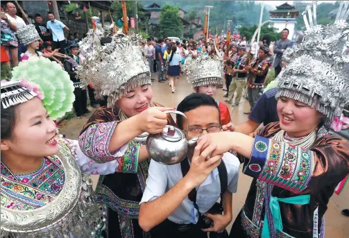  ?? TAN KAIXING / FOR CHINA DAILY ?? A tourist participat­es in a local Miao ethnic tradition in Liuzhou, Guangxi Zhuang autonomous region.