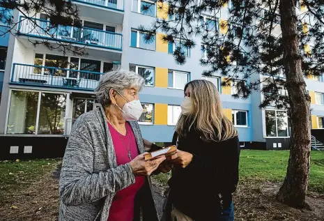  ?? Foto: Michal Růžička, MAFRA ?? Za čtenářkou Seniorce Evě Koubové v pátek dopoledne přinesla knihovnice Jana Mlynářová nové čtení. Donáškovou službu už nabízí seniorům od sedmdesáti let nebo držitelům průkazu ZTP pětadvacet poboček Městské knihovny.