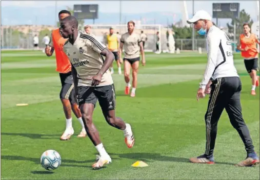  ??  ?? Zidane observa a Mendy y Militao durante un entrenamie­nto celebrado esta semana en Valdebebas.