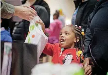  ?? [PHOTO PROVIDED] ?? A child receives a toy during the 2017 “The Big Give” Christmas giveaway event at People’s Church.