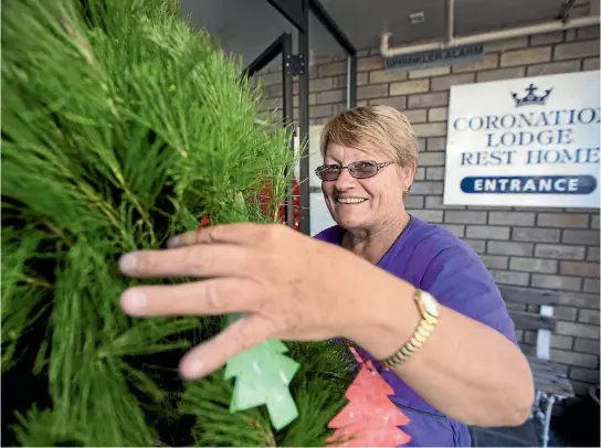  ?? ANDY JACKSON/STUFF ?? Karen Gyde, Coronation Lodge Rest Home’s recreation­al officer, is turning its donated Christmas tree into a place of remembranc­e.