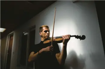  ?? NATHALIA ANGARITA/THE NEW YORK TIMES ?? Venezuelan violinist Victor Rojas on Jan. 25 at his home in Bogota, Colombia. Rojas, who arrived in Colombia in 2018, is one of the beneficiar­ies of a visa program that has offered essential benefits to migrants.