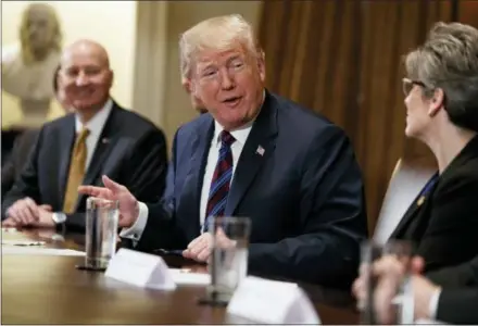  ?? EVAN VUCCI — THE ASSOCIATED PRESS ?? Gov. Pete Ricketts, R-Neb., left, listens as President Donald Trump speaks to Sen. Joni Ernst, R-Iowa, during a meeting with governors and lawmakers in the Cabinet Room of the White House, Thursday in Washington.