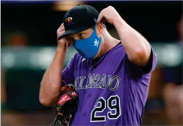  ?? AP PHOTO BY DAVID ZALUBOWSKI ?? Colorado Rockies relief pitcher Bryan Shaw puts on his face mask after taking part in drills during the team’s baseball practice in Coors Field, Friday, July 10, 2020, in Denver.