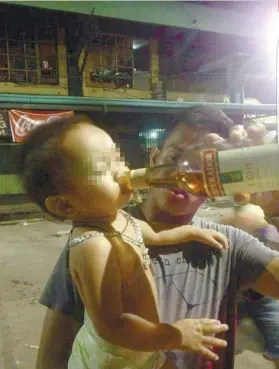  ?? FOTO DOWNLOADED FROM BUZZPINAS.COM ?? LIQUOR. Barangay and local social welfare officials are investigat­ing an incident where a 20-year-old father was photograph­ed while making his toddler son drink liquor straight out of the bottle.