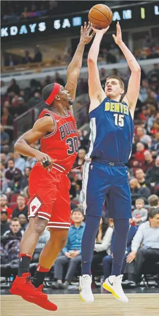  ?? Jonathan Daniel, Getty Images ?? The Nuggets’ Nikola Jokic shoots over the Bulls’ Noah Vonleh during Wednesday night’s game at the United Center in Chicago. Denver won 135-102.