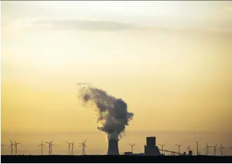  ?? MARKUS SCHREIBER/THE ASSOCIATED PRESS ?? Old and new: Wind turbines turn in the shadow of a coal power plant.