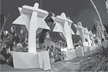  ?? GENE J. PUSKAR/AP ?? A woman places a stone on a memorial Monday outside the Tree of Life Synagogue in Pittsburgh.