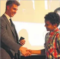  ??  ?? Jack Green addresses guests at the Canterbury Academy presentati­on evening, and right, presents the Sports Team of the Year award to Christos Eke of the Year 9 boys basketball