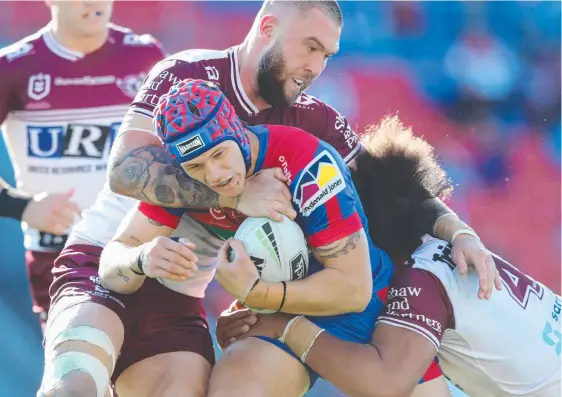  ?? Picture: GETTY IMAGES ?? Newcastle’s Kalyn Ponga is tackled by the Manly defence during the Knights’ 26-24 victory at McDonald Jones Stadium.