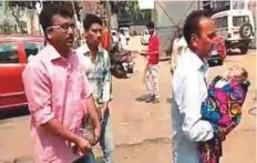  ??  ?? ■ A screenshot taken from video footage shows a man carrying a baby fitted with an oxygen mask, as others help with a cylinder, at PMCH hospital in Bihar on Thursday.