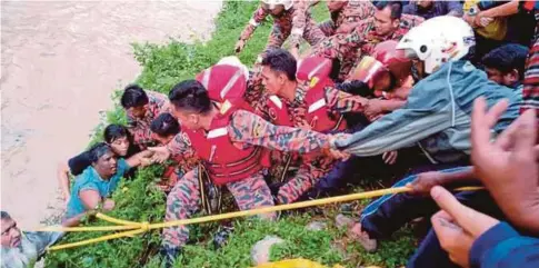  ??  ?? ANGGOTA bomba dan orang awam membantu lelaki warga Bangladesh daripada dihanyutka­n arus di Sungai Gombak berhampira­n pusat beli-belah Sogo, semalam.