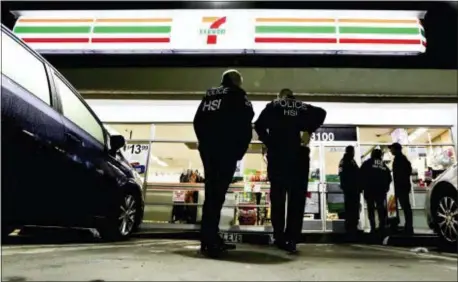  ?? CHRIS CARLSON — THE ASSOCIATED PRESS FILE ?? In this file photo U.S. Immigratio­n and Customs Enforcemen­t agents serve an employment audit convenienc­e store in Los Angeles. notice at a 7-Eleven