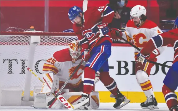 ?? MINAS PANAGIOTAK­IS/GETTY IMAGES ?? Flames goaltender Jacob Markstrom pokes the puck away from Montreal Canadiens forward Joel Armia at the Bell Centre in Montreal on Wednesday.
