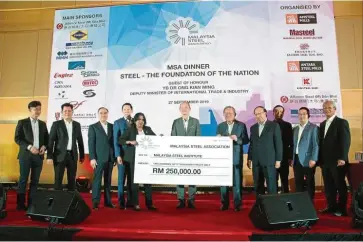  ??  ?? Mock cheque presentati­on: Cheng (fifth from right) presenting a mock cheque for RM250,000 to Internatio­nal Trade & Industry Ministry deputy secretary-general and MSI chairman Datuk Talagavath­i Karapayah (fifth from left). The handing over was witnessed by Ong (centre). The money is for MSI to promote and develop the competitiv­eness, resilience and sustainabi­lity of the local iron and steel industry.