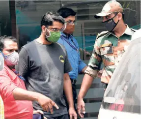  ??  ?? P.S. SARITH, the main accused in the gold smuggling case (green mask), being taken to the apartment complex near the Kerala Secretaria­t by the NIA team, in Thiruvanan­thapuram on July 20.