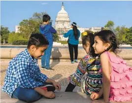  ?? JACQUELYN MARTIN AP FILE ?? A family that was evacuated from Afghanista­n celebrates Eid al-Fitr in early May by taking family photos on the National Mall near the Capitol in Washington, D.C.