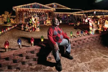  ?? Brett Deering / New York Times ?? Leonard Mosely sits in front of his Christmas light display in Del City, Okla. With lights, inflatable Santas and computer chips in high demand, delivery disruption­s have not spared those who turn their homes into illuminate­d wonderland­s.