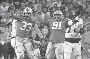  ?? ?? Ohio State’s Jack Sawyer (33) and Tyleik Williams celebrate a sack of Toledo quarterbac­k Dequan Finn.