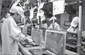  ?? PROVIDED TO CHINA DAILY ?? Foxconn employees assemble laptops at a facility in Chongqing.