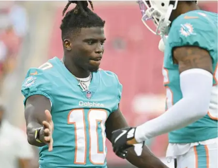  ?? JASON BEHNKEN/AP ?? Dolphins wide receiver Tyreek Hill, left, talks with fellow wide receiver Braylon Sanders on Saturday in Tampa.