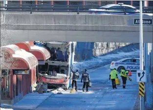  ?? CP PHOTO ?? Officials from Transport Canada look at the scene where a double-decker city bus struck a transit shelter at the start of the afternoon rush hour on Friday, at Westboro Station in Ottawa, on Saturday.