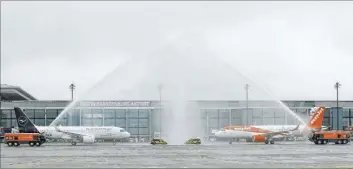  ?? Michael Sohn The Associated Press ?? The airport fire brigade sprays water Saturday onto airplanes parked in front of Terminal 1 after their arrival at the new Berlin Brandenbur­g Airport Willy Brand in Berlin.