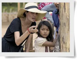  ??  ?? CIAK, SI GIRA! Angelina Jolie sul set di Per primo hanno ucciso mio padre con Sareum Srey Moch, la bambina che interpreta la protagonis­ta del ilm.