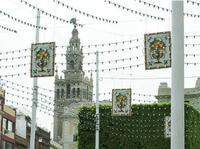  ?? KIKO HURTADO ?? Vista de las calles del centro de Sevilla, con la Giralda al fondo, engalanada­s con adornos de Feria estos días