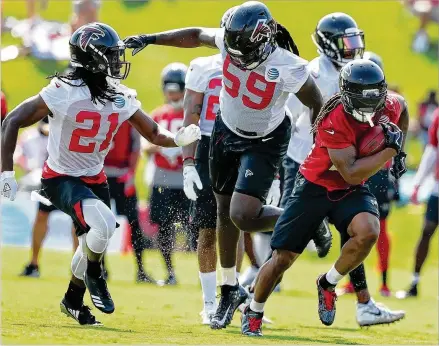  ?? CURTIS COMPTON / CCOMPTON@AJC.COM ?? Cornerback Desmond Trufant (left) and linebacker De’Vondre Campbell chase running back Devonta Freeman on a reception during the first day of practice at Falcons training camp in Flowery Branch. Trufant is back from a season-ending injury.
