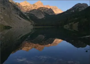  ?? MIKE ECKEL, THE ASSOCIATED PRESS ?? Pika Peak, shown at sunset, is mirrored in Echo Lake, one of scores that dot Montana’s Absaroka-Beartooth Wilderness, making the region popular for hikers and anglers alike.