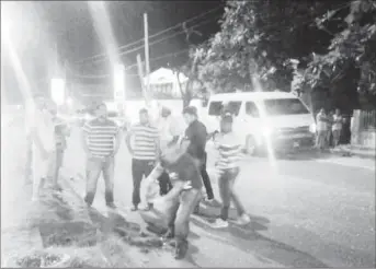  ??  ?? Family members of Salim Deen look on as police investigat­ions gather evidence at the scene last evening.