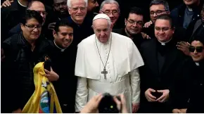  ?? AP ?? Pope Francis poses for a picture with priests during the weekly general audience at the Vatican.