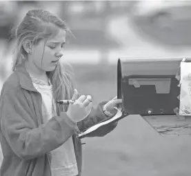  ?? ADAM CAIRNS/USA TODAY NETWORK ?? After taping her first tic-tac-toe win to the side of her family’s mailbox, Julia Hughes, 11, weighs her move in the next round.
