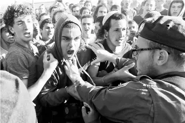  ??  ?? Israeli settlers scuffle with security forces at the Netiv Haavot settlement, near Bethlehem, in the occupied West Bank. — AFP photo