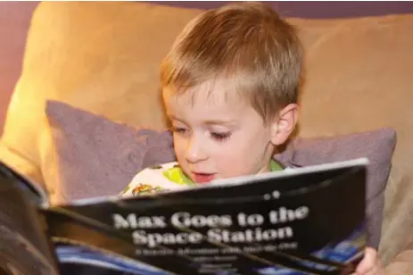  ??  ?? Donovan Allen, 4, of Indianapol­is, who likes to read along with the astronauts at bedtime, leafs through