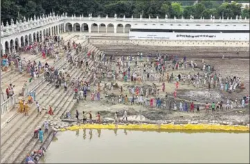  ?? SANJEEV KUMAR/HT ?? Devotees cleaning a half of Gurusar Sarovar at Takht Damadma Sahib in Talwandi Sabo; the other half, which will be cleaned when this half is done, has four feet of water for now, so that the fish are safe.