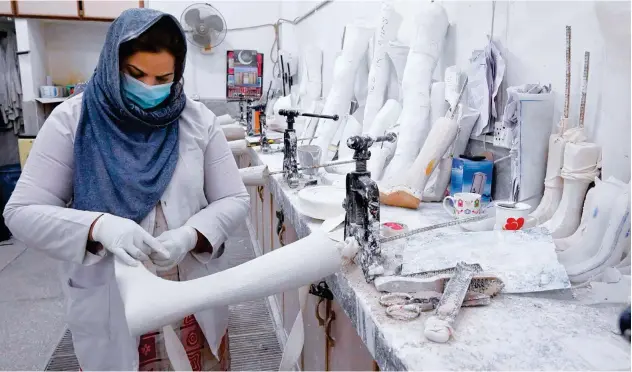  ?? Agence France-presse ?? ↑
A technician works on an artificial limb at a workshop in a hospital in Lahore on Thursday, on the occasion of Internatio­nal Day of Persons with Disabiliti­es.