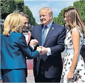  ??  ?? President Trump clasps the hands of Emmanuel and Brigitte Macron as Melania Trump looks on