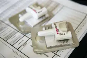  ?? MARY ALTAFFER — THE ASSOCIATED PRESS FILE ?? A Narcan nasal device which delivers naloxone lies on a counter Tuesday as a health educator gives instructio­ns on how to administer it in the Brooklyn borough of New York. On Wednesday the U.S. government told doctors to consider prescribin­g the overdose antidote naloxone to many more patients who take opioid painkiller­s.