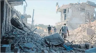  ?? SYRIAN CIVIL DEFENSE WHITE HELMETS THE ASSOCIATED PRESS ?? Syrian troops have been on the offensive since April 30, and have captured all rebel-held areas in the adjoining Hama province. Here, people inspect the buildings following the bombing.