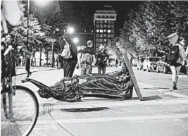  ?? EMILY HAMER/WISCONSIN STATE JOURNAL ?? The “Forward” statue lies in the street Tuesday on Capitol Square in Madison, Wisconsin.