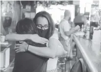  ?? REUTERS ?? Bartender Debbie Greenberg hugs a returning patron at Cubbyhole in the Manhattan borough of New York City on May 27.