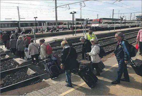  ?? VICENÇ LLURBA ?? Cruzando las vías. El grupo de jubilados que regresaban de viaje en AVE acabó caminando por las vías para evitar subir y bajar escaleras con las maletas en la estación de tren de Tarragona, que no tiene ascensor