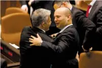  ?? (Flash 90) ?? YESH ATID chairman Yair Lapid (left) and Bayit Yehudi leader Naftali Bennett embrace at the Knesset after the Equal Sharing of the Burden Bill became law yesterday.