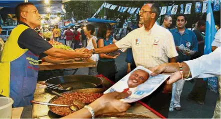  ??  ?? Candidate: On the campaign trail in 2004, meeting people at a pasar malam in Petaling Jaya.