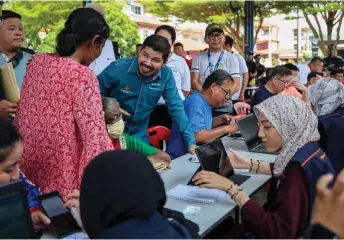  ?? — Bernama photo ?? Mohd Uzir speaks with members of the public registerin­g for Padu.