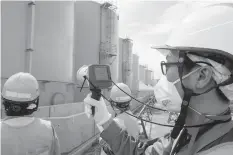  ?? AGENCE FRANCE PRESSE PHOTO ?? In this picture, a staff member of Tokyo Electric Power Company measures radiation levels around the storage tanks of radiation-contaminat­ed water at the tsunami-crippled Tokyo Electric Power Company (TEPCO) Fukushima Daiichi nuclear power plant in...