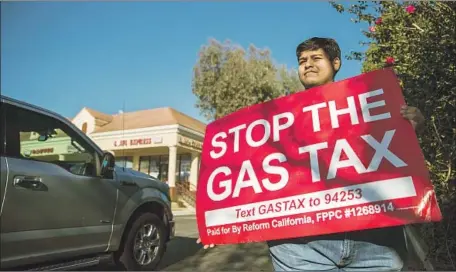  ?? Allen J. Schaben Los Angeles Times ?? DAVID GUERRERA directs motorists to sign a petition for a proposed ballot measure to repeal the increase in California’s gas tax during a rally in Corona in January. A new measure for 2020 seeks to provide funding to fix roads while halting the state’s high-speed rail project.